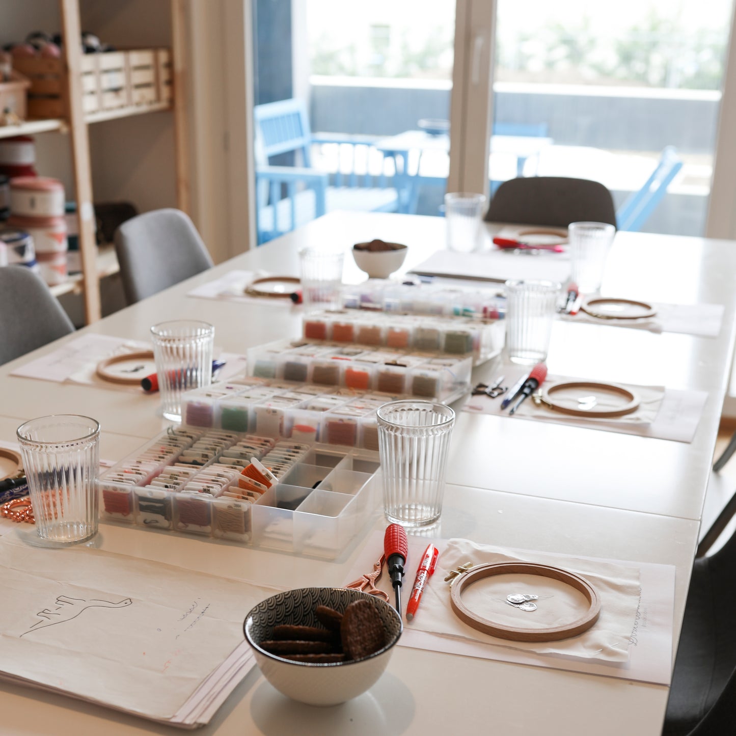 Atelier de broderie en petit groupe, avec tambours, fils et créations en cours sur la table