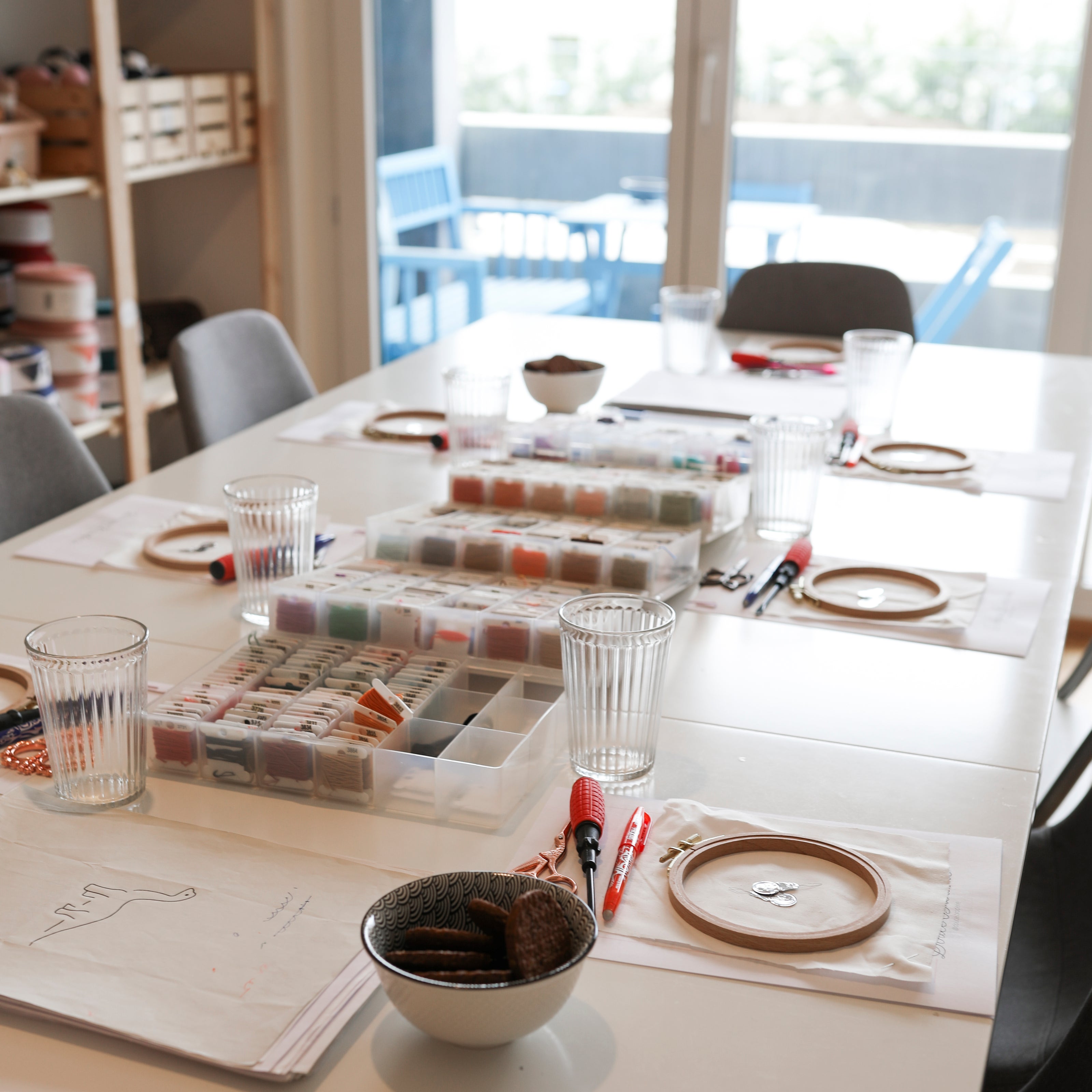 Atelier de broderie en petit groupe, avec tambours, fils et créations en cours sur la table